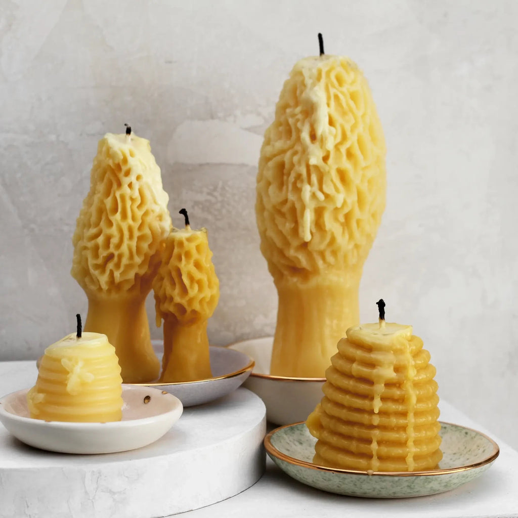group of lit beeswax candles on trinket dishes