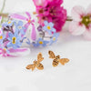 Mini Bee Stud Earrings with flowers in the background