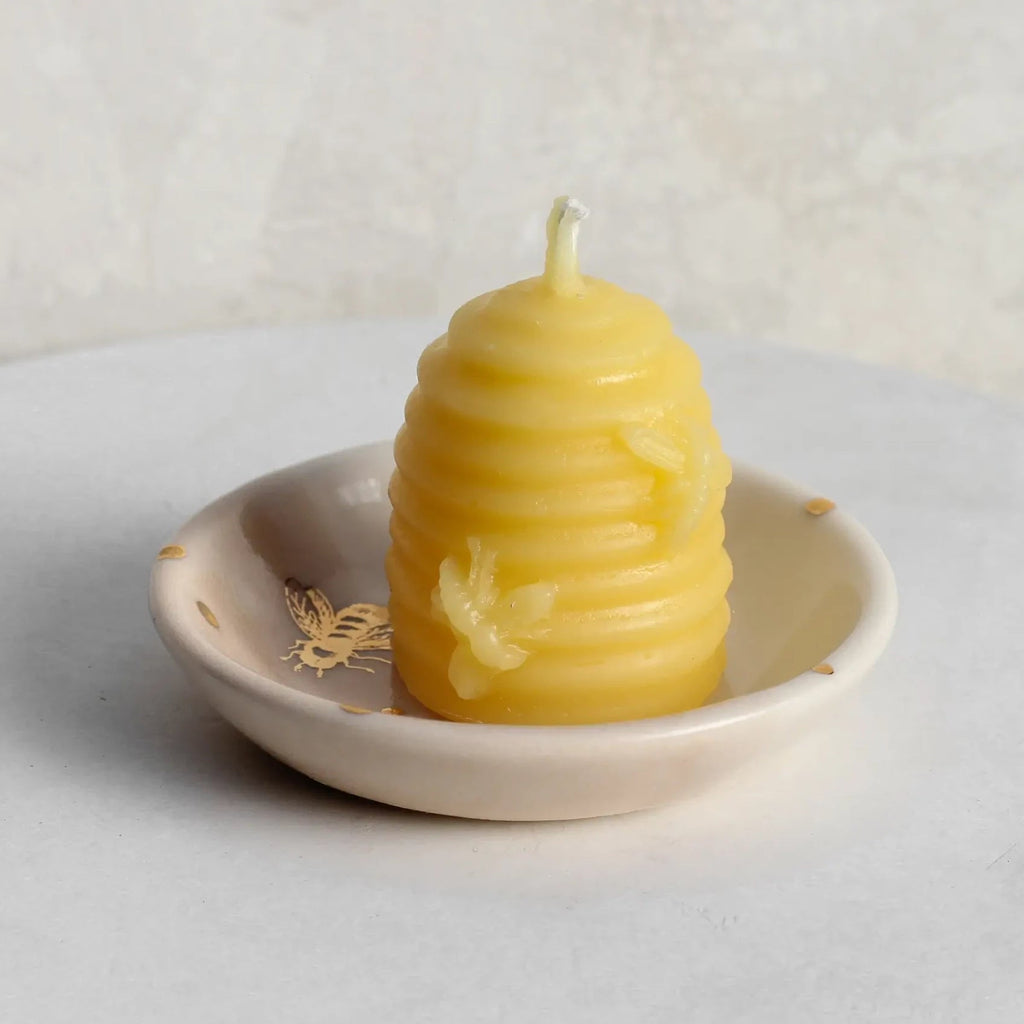 Little beeswax beehive candle in a trinket dish